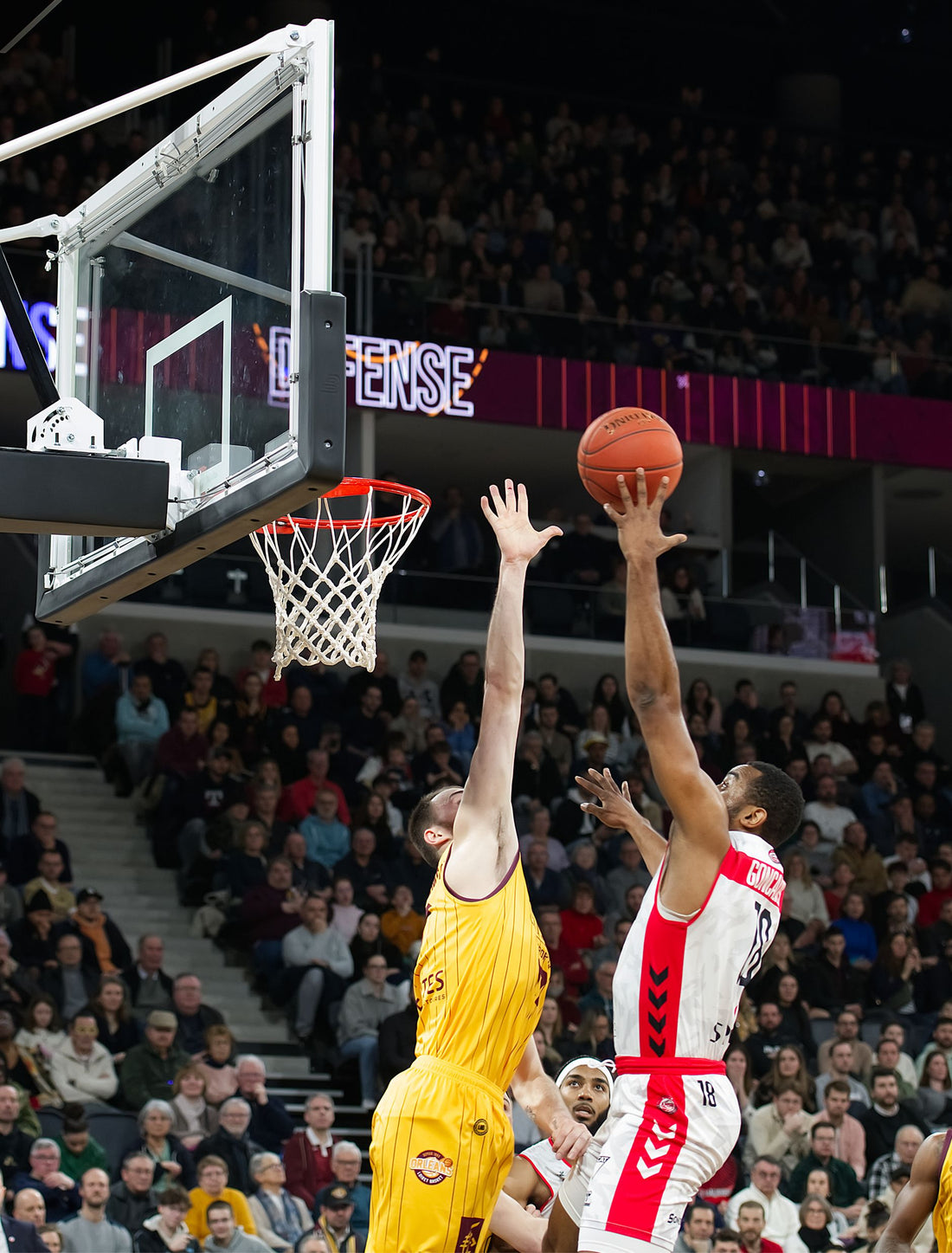 Cestista che schiaccia a canestro durante una partita di basket